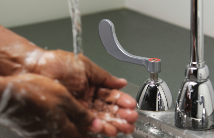 Hands being washed with antimicrobial faucet handle